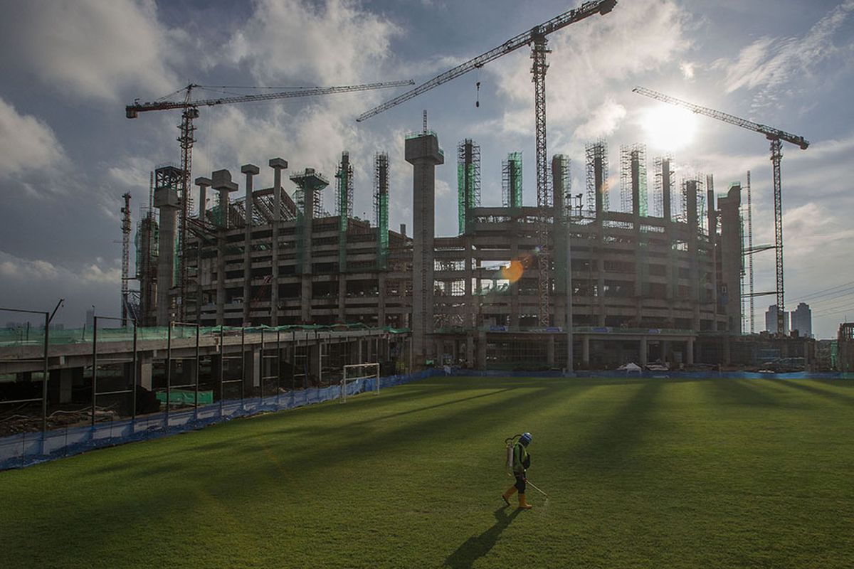 Pekerja merawat rumput lapangan latihan di lokasi pembangunan Jakarta International Stadium (JIS) di Papanggo, Tanjung Priok, Jakarta Utara, Selasa (9/3/2021). Saat ini kemajuan pembangunan stadion yang diproyeksikan berkapasitas 82.000 penonton itu mencapai 49,94 persen (data terakhir PT Jakarta Propertindo per 9 Maret 2021).