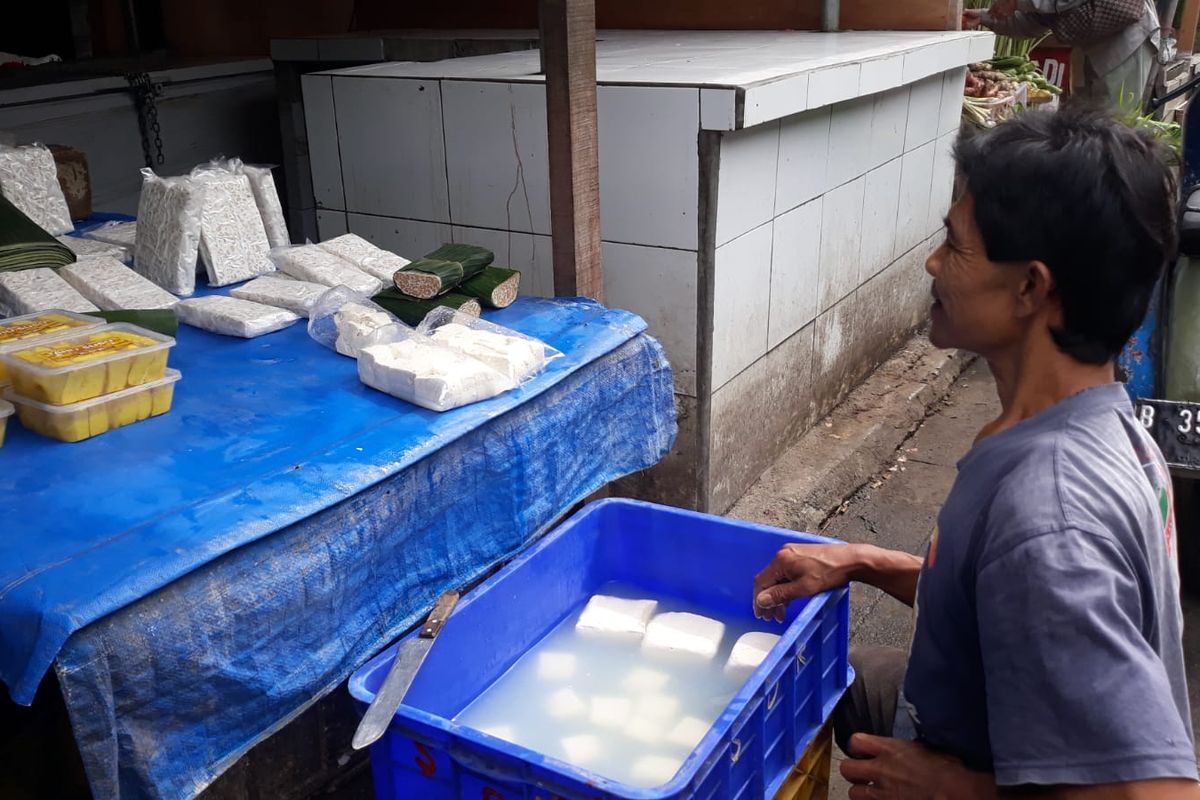 Pedagang kembali berjualan tahu dan tempe di Pasar Kramatjati, Jakarta Timur, Kamis (24/2/2022).  Harga tahu dan tempe yang dijual naik Rp 1.000 pascamogok jualan tiga hari.