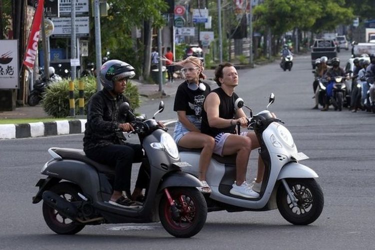 Sejumlah turis asing mengendarai sepeda motor tanpa mengenakan helm di Jalan Sunset Road, Kuta, Badung, Bali, Selasa (28/2/2023).