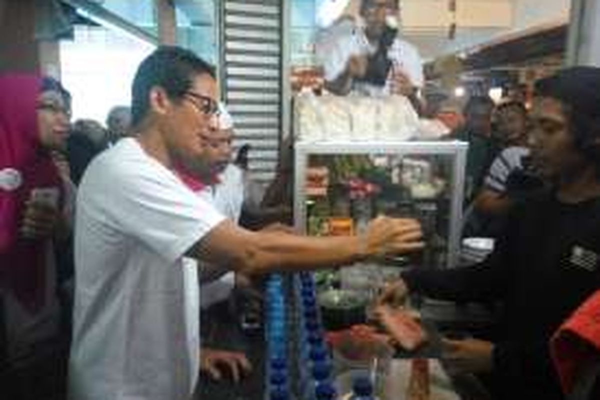 Calon wakil gubernur DKI Jakarta, Sandiaga Uno saat memesan kopi di sebuah warung di Pasar Kramatjati, Jakarta Timur pada Minggu (4/12/2016).