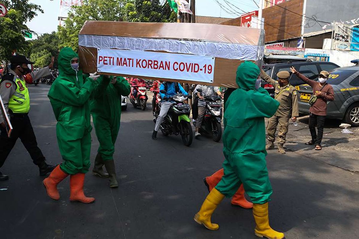 Petugas dari Kelurahan Pondok Labu membawa peti mati saat sosialisasi mencuci tangan, menjaga jarak, menggunakan masker di kawasan RW 05 dan Pasar Pondok Labu, Jakarta Selatan, Rabu (9/9/2020). Sosialisasi terkait bahaya penularan Covid-19 ini dihadiri Camat Cilandak.