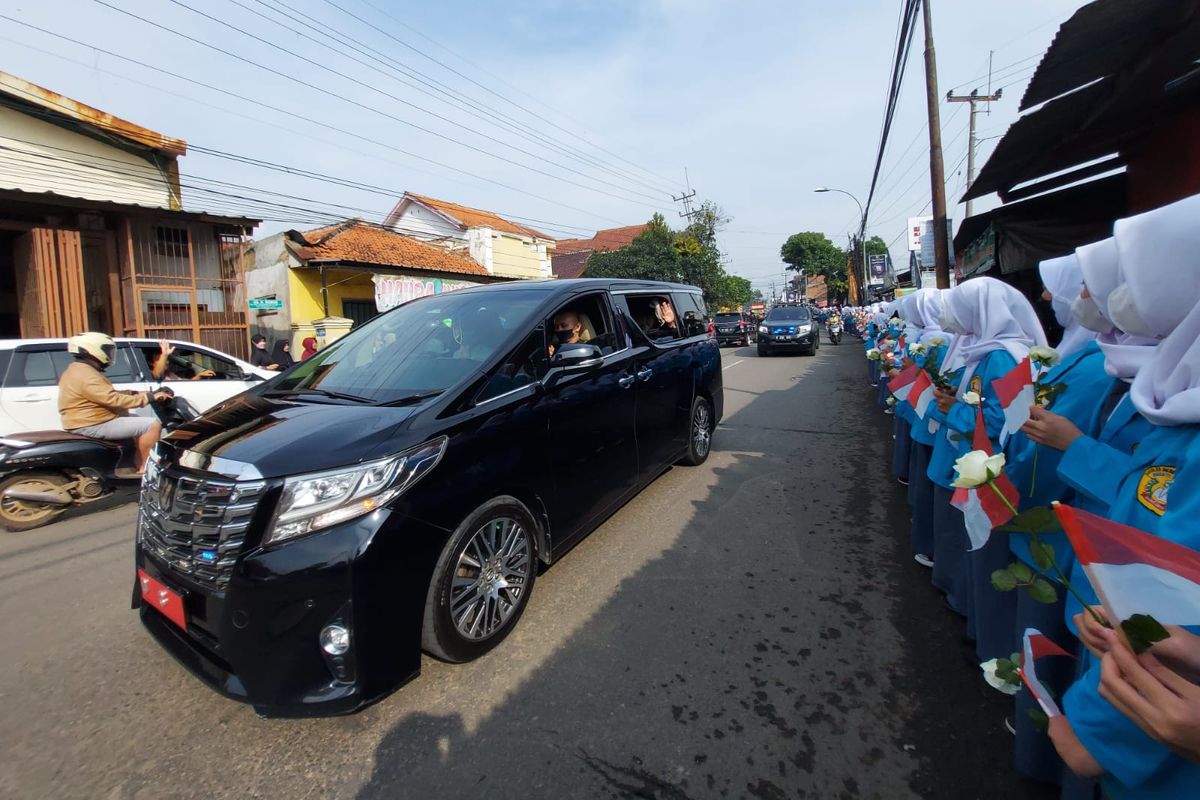 Siswa-siswi dari tingkat sekolah dasar (SD) sampai menengah ke atas (SMA), berbaris di tepi Jalan Raya Soreang, Kabupaten Bandung, Jawa Barat, menyambut rombongan pengantar jenazah Emmeril Kahn Mumtadz (Eril), yang hendak menuju tempat peristirahatan terakhirnya, di Cimaung, Kabupaten Bandung, Jawa Barat, Senin (13/5/2022).