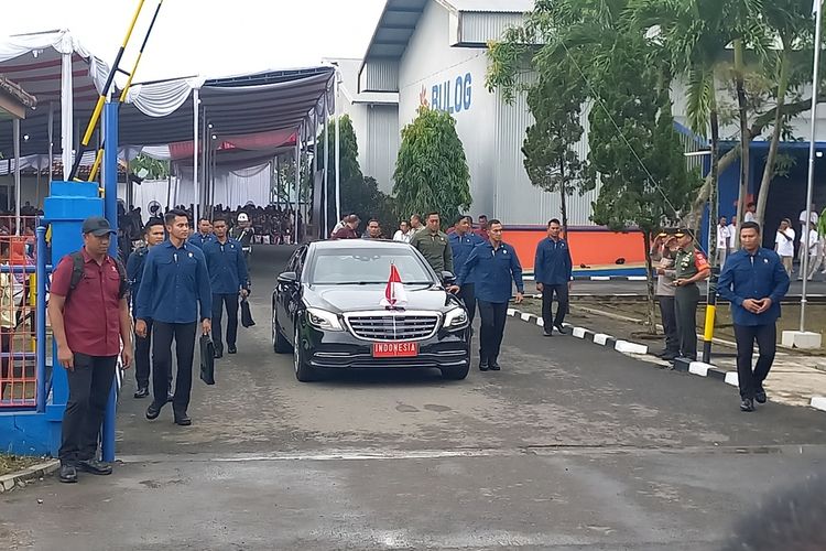 Jokowi saat keluar dari Gudang Bulog, sempat membagikan kaus kepada masyarakat yang menunggu, Selasa (30/1/2024)