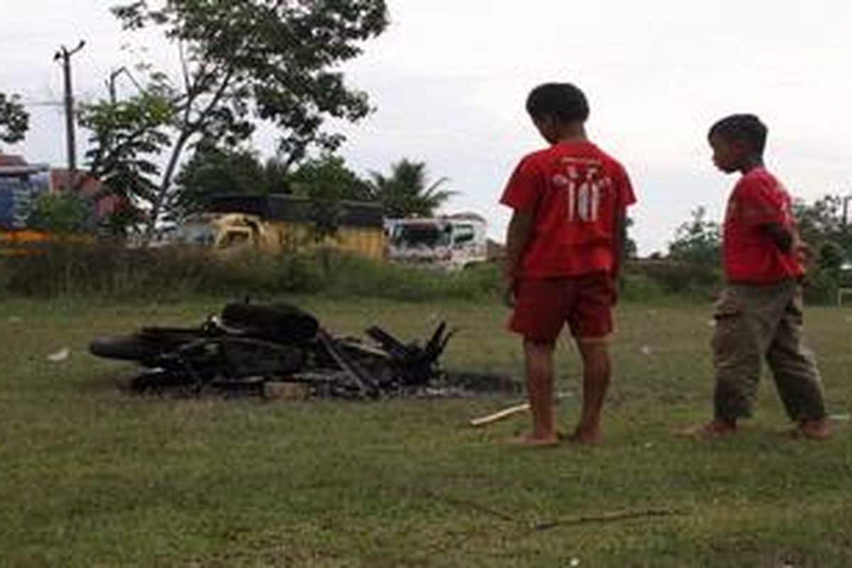 Sisa-sisa sepeda motor yang dibakar dalam bentrokan antarpemuda di Kecamatan Mesuji, Kabupaten Ogan Komering Ilir, Sumatera Selatan, Senin (18/6/2012). Lalulintas di  jalan lintas timur Palembang-Lampung sempat macet hingga tujuh jam akibat kejadian ini. Hingga malam, suasana masih mencekam. 