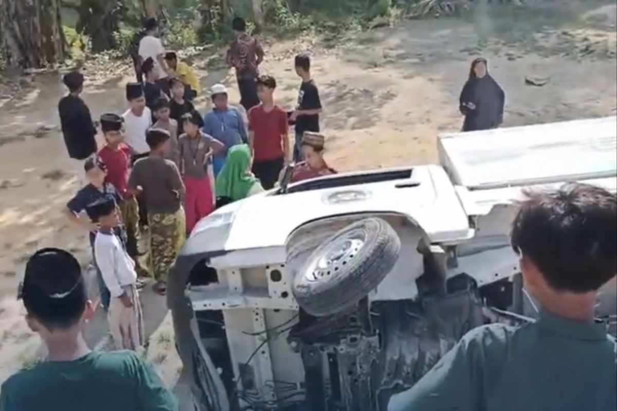 Warga melakukan evakuasi mobil box setelah terbalik di Desa Bangkes, Kec. Kadur Pamekasan, Jumat (26/9/2025)