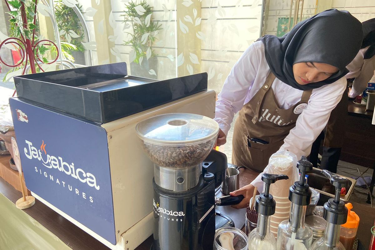 Barista tuli, Della sedang melakukan tamping untuk memadatkan bubuk kopi yang akan diraciknya. 