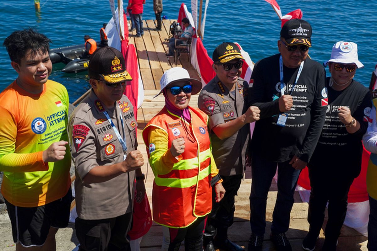 Ketua Wanita Selam Indonesia (WASI) Tri Tito Karnavian dan Kapolri Jenderal (Pol) Tito Karnavian dalam aksi pemecahan rekor dunia selam Guinness World Records di Pantai Manado, Kawasan Megamas, Manado, Sulawesi Utara, Sabtu (3/8/2019).