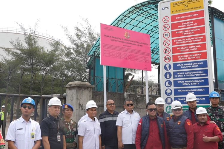 Penyidik Kejaksaan Agung saat menempelkan stiker keterangan penyitaan di aset PT Orbit Terminal Merak, CIlegon, Banten, Rabu (11/6/2025).(Dok. Kejaksaan Agung)