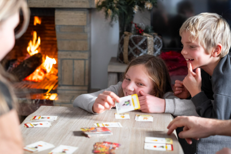 Ilustrasi perayaan Natal dengan bermain permainan bersama keluarga.