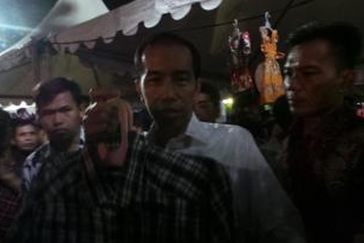 Gubernur DKI Jakarta Joko Widodo membeli kemeja di Kaki Lima Night Market, Jakarta, Sabtu (5/10/2013) malam.