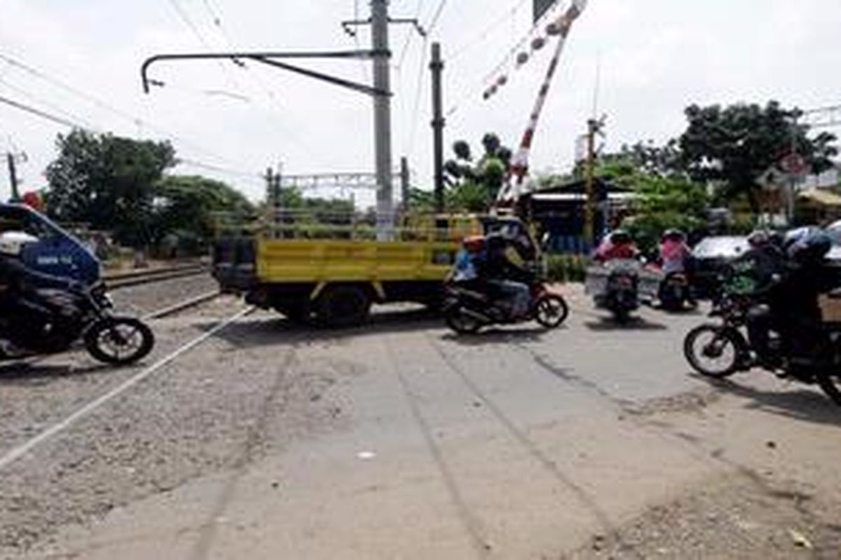 Pengguna jalan melintas di perlintasan kereta api di sekitar Pasar Bintaro, Pesanggrahan, Jakarta Selatan, Kamis (4/4/2013). Pertemuan lalu lintas dari empat arah di  pintu perlintasan itu menjadi penyebab kemacetan. Kondisi ini tentunya menyebabkan kawasan itu rawan kecelakaan yang melibatkan kereta api.
 
