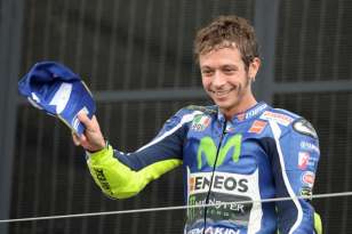 Pebalap Movistar Yamaha asal Italia, Valentino Rossi, menyapa penggemar setelah berhasil finis di urutan ketiga pada balapan GP Inggris di Sirkuit Silverstone, Minggu (4/9/2016).