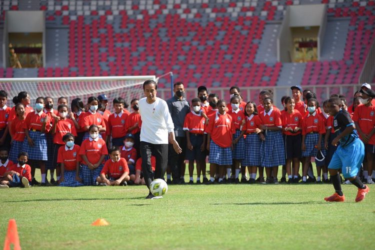 Presiden Joko Widodo melakukan teknik passing bola kepada salah satu putra Papua dalam peresmian Papua Football Academy.
