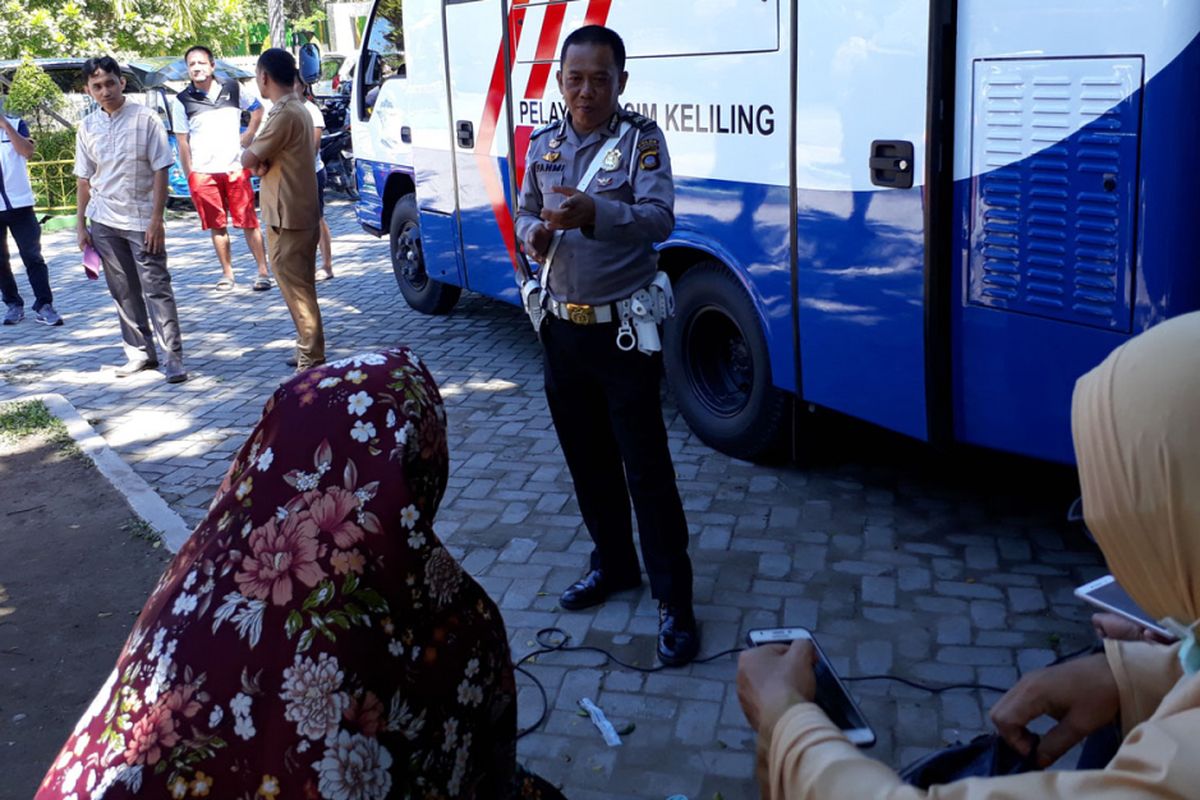 Aiptu Ramdan Fahmi saat berbagi ilmu dengan warga Gorontalo yang mengantre layanan perpanjangan SIM di Taman Kota, Kota Gorontalo.