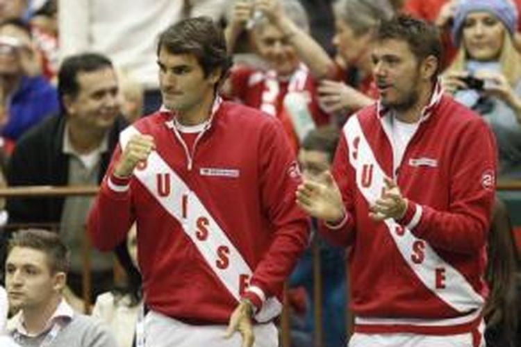 Petenis Swiss, Roger Federer (kiri) dan Stanislas Warinka memberi dukungan saat timnya bertemu Serbia pada babak pertama Davis Cup 2013, 31 Januari-2 Februari. Swiss menang 3-2.