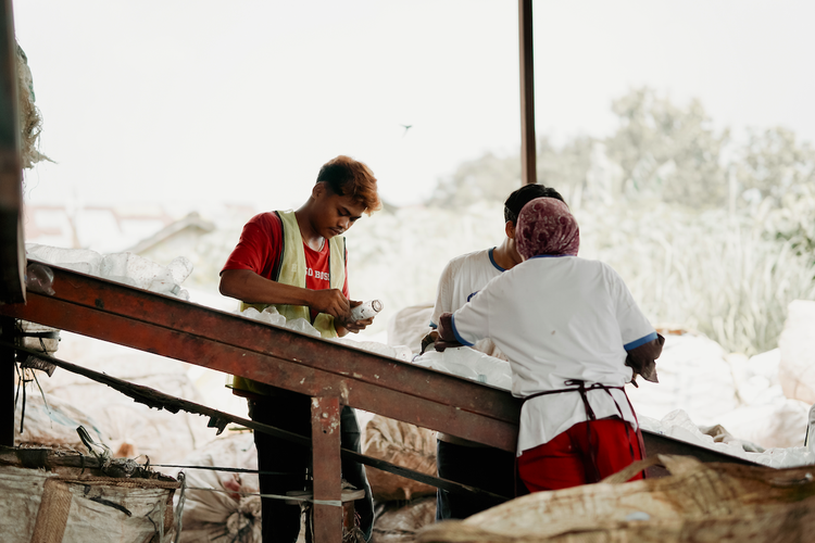 Para pekerja menyortir plastik PET pasca-konsumsi