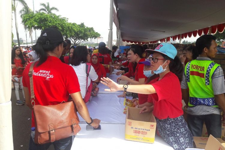 Suasana pembagian sembako dalam acara Untukmu Indonesia di Monas, Jakarta Pusat, Sabtu (28/4/2018).