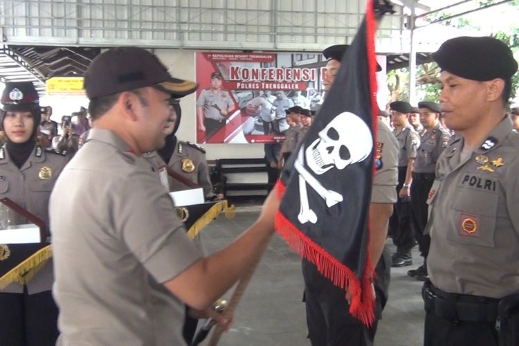 Kapolres Trenggalek memberikan bendera tengkorak kepada salah satu anggota polsek jajaran, yang paling minim memberikan laporan kegiatan dalam bidang kehumasan (04/11/2019).