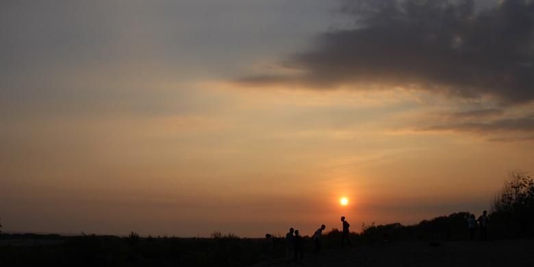 Wisatawan menikmati matahari tenggelam dari Gumuk Pasir Parangkusumo, Bantul, Yogyakarta, Minggu (23/8/2015). Untuk masuk ke area Gumuk Pasir Parangkusumo, wisatawan tidak dikenakan biaya.