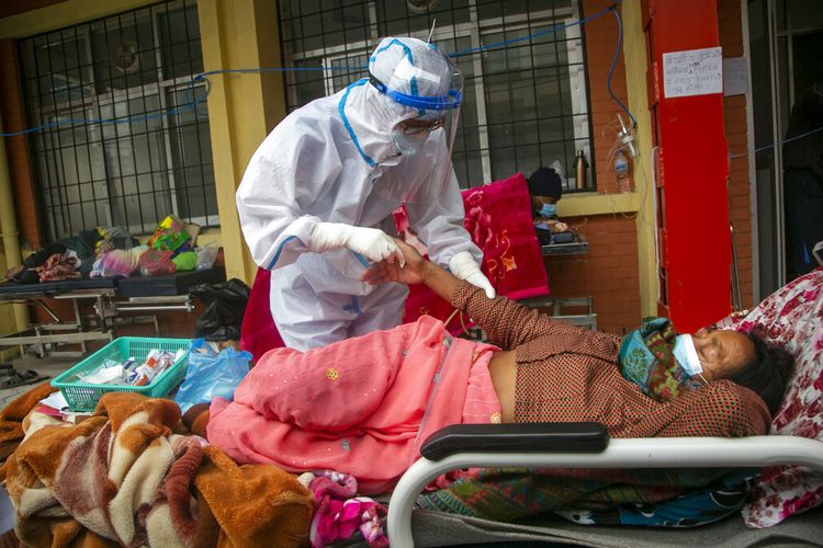 Paramedis Nepal merawat pasien Covid-19 di luar bangsal darurat rumah sakit yang dikelola pemerintah di Kathmandu, Nepal, Senin (10/5/2021).