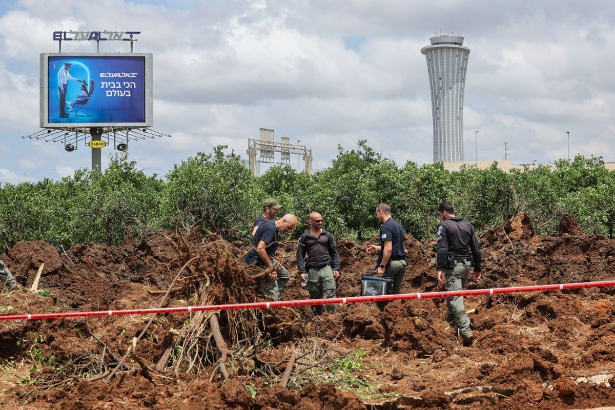 Anggota dinas keamanan Israel memeriksa kawah di dekat jalan di luar bandara Ben Gurion Israel setelah rudal yang diluncurkan dari Yaman menghantam daerah tersebut pada 4 Mei 2025. Sebuah rudal yang diluncurkan dari Yaman menghantam dekat bandara internasional utama Israel pada 4 Mei, kata otoritas Israel, sebuah serangan yang menghentikan lalu lintas udara untuk sementara waktu dan memicu ancaman pembalasan.