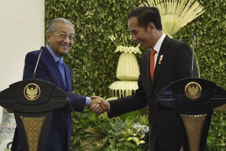 Presiden Joko Widodo (kanan) berjabat tangan dengan Perdana Menteri Malaysia Mahathir Mohamad (kiri) usai menyampaikan keterangan pers di Istana Bogor, Jawa Barat, Jumat (29/6). Kunjungan kenegaraan tersebut membahas permasalahan perbatasan kedua negara, tenaga kerja, dan sekolah bagi anak Tenaga Kerja Indonesia yang berada di Malaysia. ANTARA FOTO/Puspa Perwitasari/Spt/18
