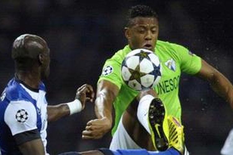 Gelandang serang Malaga dari Brasil, Julio Baptista (kanan), berebut bola melawan bek FC Porto dari Perancis, Eliaquim Mangala, dalam laga perdana 16 besar Liga Champions di Stadion Dragao, Selasa (19/2/2013). 