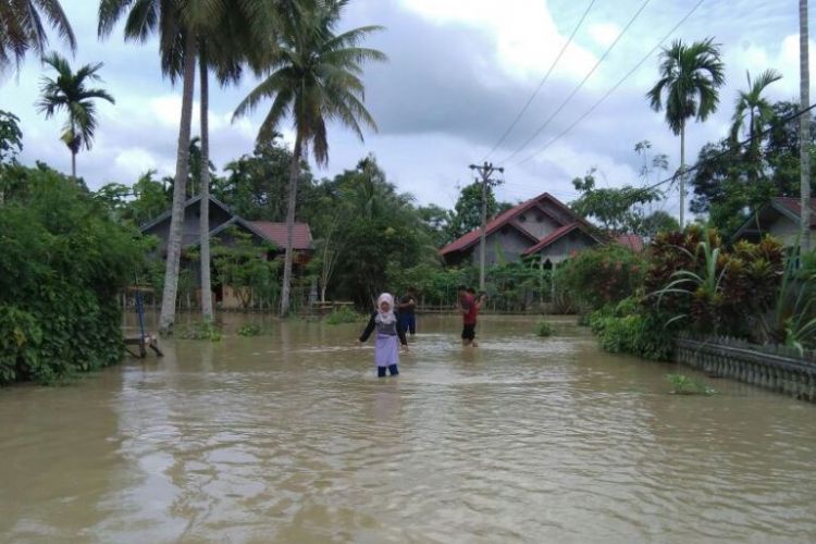 Warga melintasi di lokasi banjir Desa Hagu, Kecamatan Matangkuli, Aceh Utara, Selasa (28/3/2017)