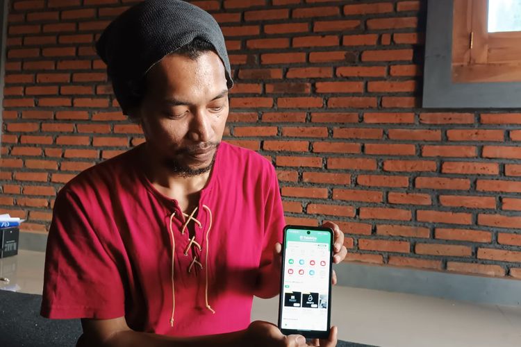 Evan Helga (32), warga Desa Talok, Kecamatan Turen, Kabupaten Malang menunjukkan aplikasi Talok Go buatannya untuk mewadahi UMKM Desa.