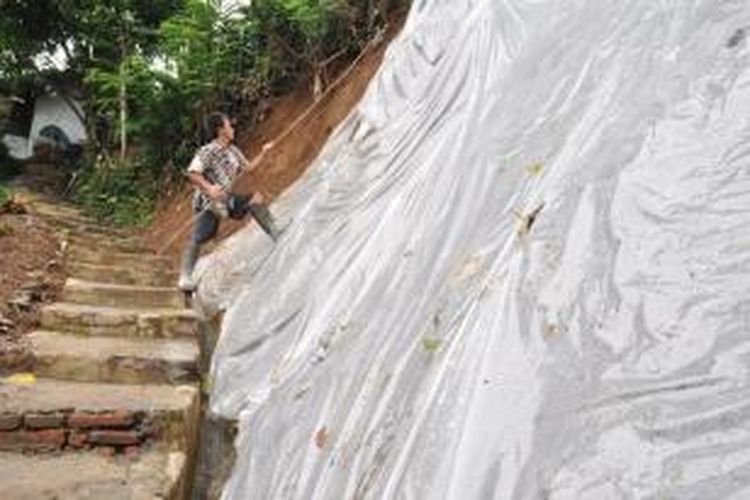 Warga menutupi bagian tebing yang longsor di warga Dusun Banaran, Gemawang, Kecamatan Jambu, Kabupaten Semarang. 