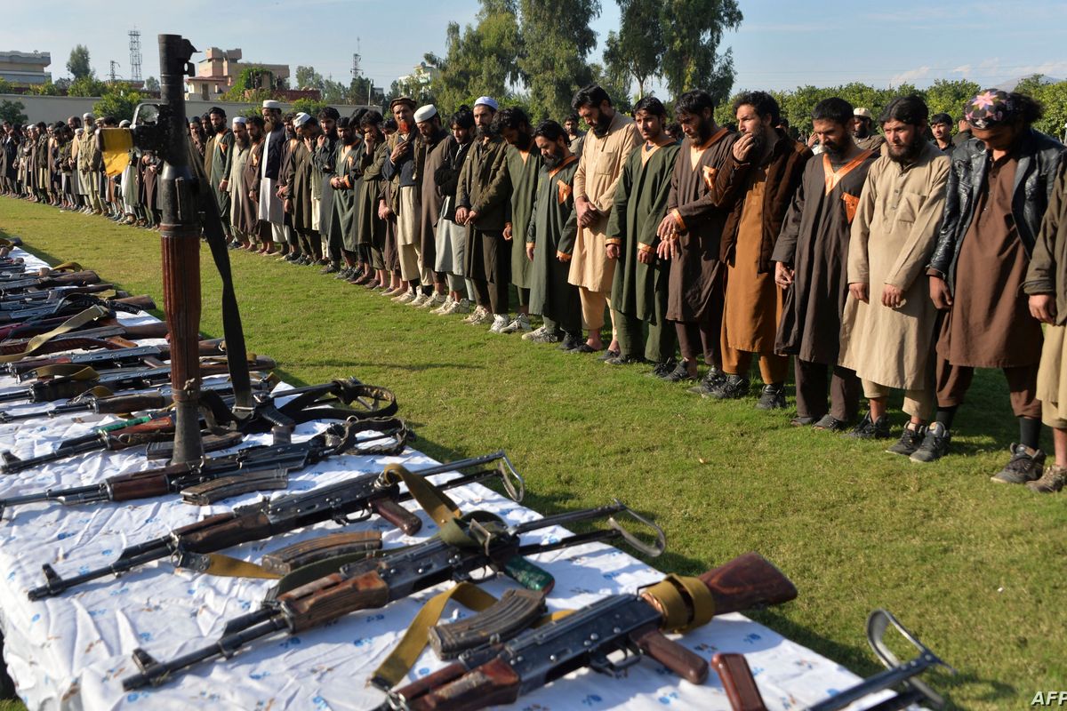 In this file photograph taken on November 17, 2019, members of the Islamic State [IS] group stand alongside their weapons, following their surrender to the Afghan government in Jalalabad, capital of Nangarhar province 