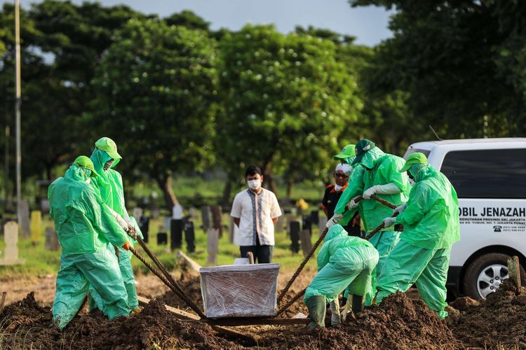 Petugas pemakaman membawa peti jenazah pasien suspect virus corona atau Covid-19 di TPU Tegal Alur, Jakarta Barat, Kamis (26/3/2020). Pemprov DKI Jakarta telah menyiapkan dua tempat pemakaman umum (TPU) untuk memakamkan pasien terjangkit virus corona (Covid-19) yang meninggal dunia, yakni di TPU Tegal Alur di Jakarta Barat dan TPU Pondok Ranggon di Jakarta Timur. Jenazah yang dapat dimakamkan di sana, yakni yang berstatus pasien dalam pengawasan (PDP) dan berstatus positif terjangkit virus corona.