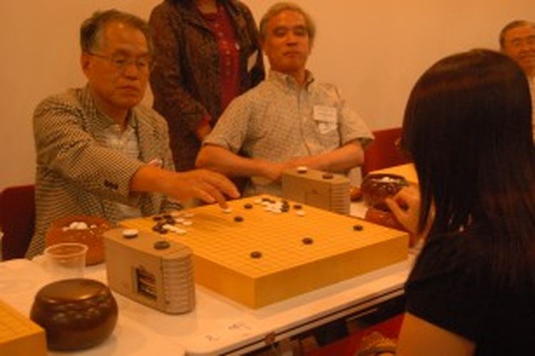 Salah satu Master Igo dari Jepang, Takao Yoshinori (kiri), bertanding melawan anggota Federasi Igo Indonesia, Katherine (kanan), di Turnamen Persahabatan Igo 2013 yang digelar di Japan Foundation, Jalan Jendral Sudirman, Jakarta, Minggu (30/6/2013).