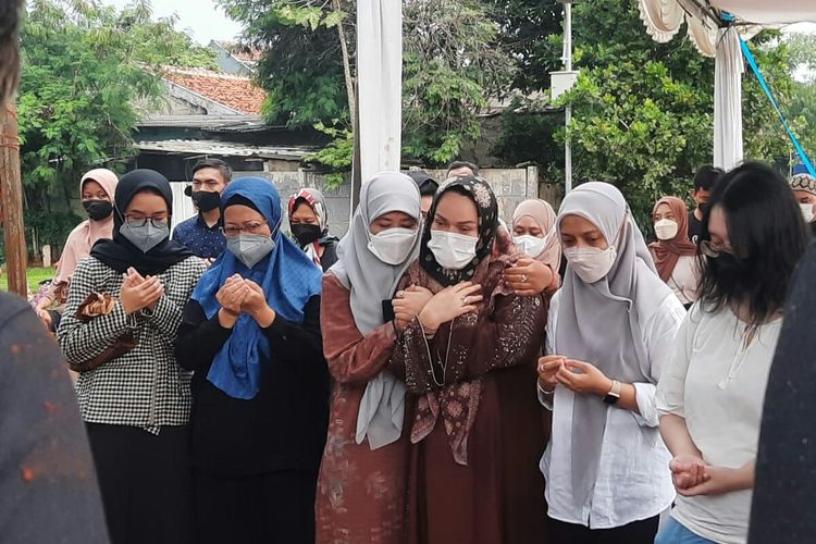 Istri mendiang penulis Hilman Hariwijaya, Dewi Natalia (baju coklat, hijab hitam) saat mendampingi prosesi pemakaman sang suami di TPU Jombang, Tangerang Selatan, Rabu (9/3/2022) sore.