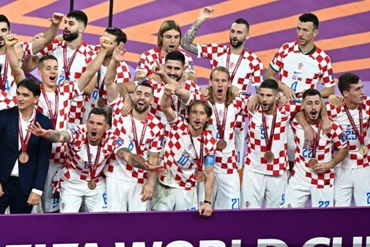 Para pemain dan pelatih Kroasia saat merayakan keberhasilan merebut peringkat ketiga Piala Dunia 2022. Kroasia meraih posisi ketiga seusai menang atas Maroko. Laga Kroasia vs Maroko yang berakhir 2-1 untuk kemenangan Vatreni sudah rampung bergulir di Stadion Internasional Khalifa pada Sabtu (17/12/2022). (Photo by Anne-Christine POUJOULAT / AFP)