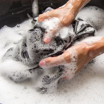 Ilustrasi mencuci pakaian hitam dengan tangan