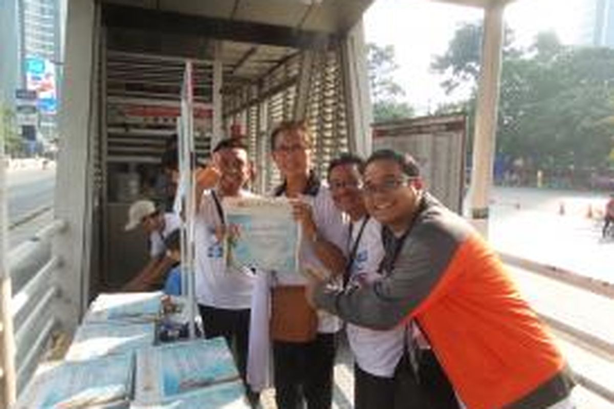 Aktor senior Pong Hardjatmo (tengah) berfoto bersama dengan sejumlah petugas outlet koran Kompas di Halte Tosari ICBC, Minggu (28/6/2015), yang bertepatan dengan hari ulang tahun ke-50 Harian Kompas.