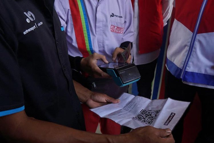 Pembeli menunjukan kode QR saat membeli BBM di SPBU.