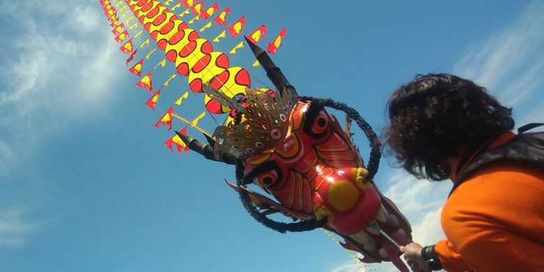 Salah seorang tim layang-layang mempersiapkan diri menerbangkan layangan dengan figur naga, dalam gelaran Jogja Air Show (JAS) 2018 yang dipusatkan di Pantai Depok dan Parangkusumo, Kabupaten Bantul, DI Yogyakarta, Sabtu (17/2/2018). JAS merupakan ajang tahunan yang digelar Lanud Adisutjipto Yogyakarta bekerja sama dengan Dinas Pariwisata DIY, yang pada tahun ini berlangsung selama 2 hari, yaitu 17 dan 18 Februari.