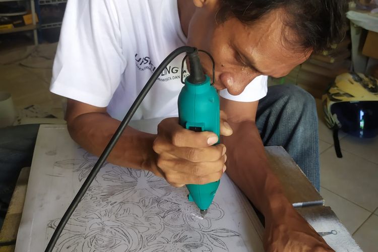 Potret Alip Damanto, owner Syahda Craft ketika memproduksi sebuah hiasan dinding ukir. Ia hanya menggunakan alat-alat konvensional untuk memotong paralon hingga proses finishing. 