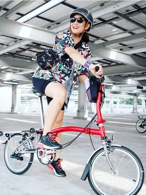 Dian Sastrowardoyo berpose di atas sepeda Brompton.