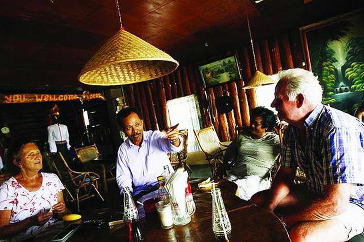 Pasangan suami istri wisatawan asal Belanda, Neli dan Martin, berbincang dengan keluarga Leo Sidabutar di sebuah kafe di Tuktuk, Pulau Samosir, Sumatera Utara, Kamis (11/2). Hampir setiap tahun pasangan ini mengunjungi dan menikmati liburan di Tuktuk.