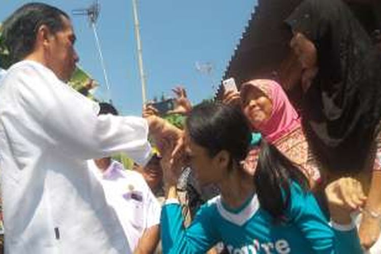 Presiden Joko Widodo bersalaman dengan anak penyandang disabilitas saat membagi-bagikan sembako di Kampung Pasir KKongsen, Rangkasbitung, Senin 4 Juli 2016.