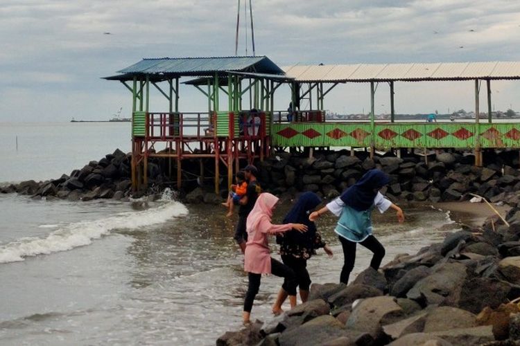 Sejumlah wisatawan mengunjungi objek wisata pantai di Kota Tegal sebelum pemberlakuan jumlah pengunjung, Minggu (10/1/2021).