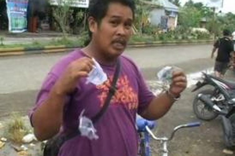 Karena kecewa tak diperbolehkan mencoblos, Jon, warga Mamuju Utara, Sulawesi Barat mengamuk dan merobek surat undangan memilih di TPS, Rabu (9/4/2014). 
