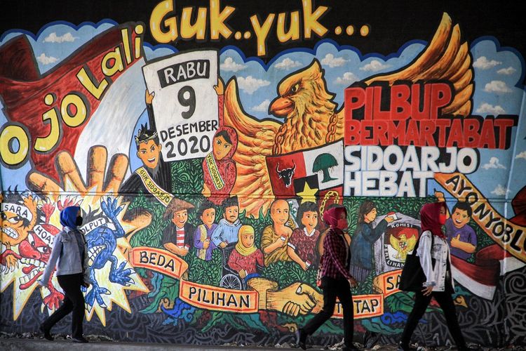 Warga berjalan di depan mural Pemilu 2020 di kawasan Jati Raya, Sidoarjo, Jawa Timur, Jumat (28/8/2020). Mural tersebut dibuat sebagai salah satu bentuk sosialisasi serta ajakan kepada masyarakat untuk menggunakan hak pilihnya pada Pilkada serentak 9 Desember mendatang. ANTARA FOTO/Umarul Faruq/wsj.