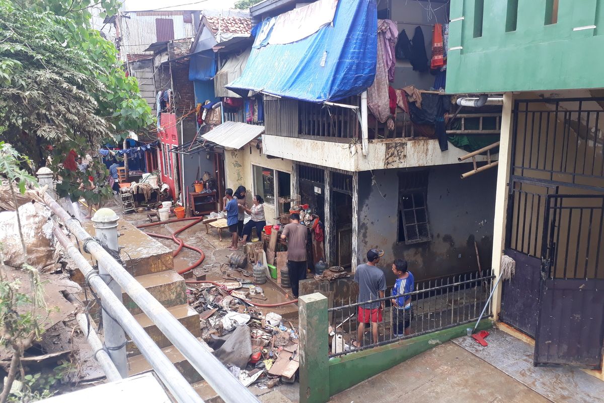 Warga Kampung Pulo, Kelurahan Kampung Melayu, Jatinegara, Jakarta Timur, Minggu (5/1/2020), saat sedang membersihkan rumah pascabanjir.