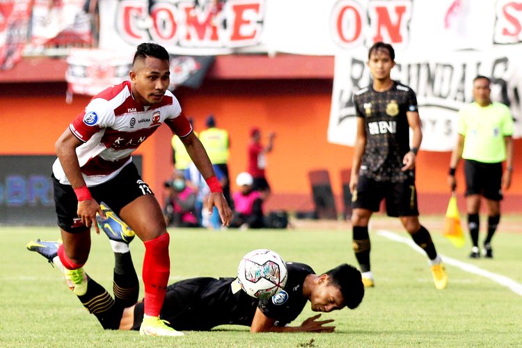 Pemain Madura United Dodi Alexvan Djin melawati pemain Bhayangkara FC saat pertandingan pekan ke-9 Liga 1 2022-2023 yang berakhir dengan skor 1-0 di Stadion Gelora Ratu Pamelingan Pamekasan, Kamis (8/9/2022) sore.