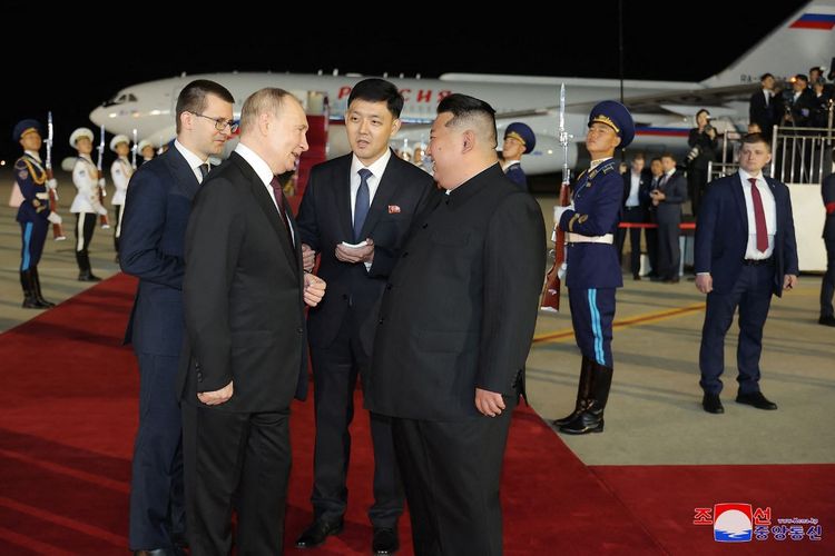 Pemimpin Tertinggi Korea Utara Kim Jong Un (kanan) berbincang dengan Presiden Rusia Vladimir Putin (kiri) saat kedatangannya di Bandara Internasional Pyongyang, ibu kota Korea Utara, Rabu (19/6/2024).
