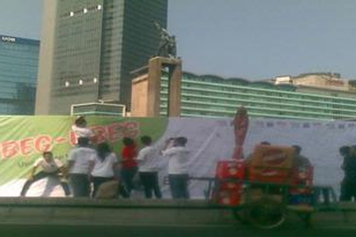 Sejumlah warga Jakarta menuliskan kritik, saran, terkait kota Jakarta pada spanduk yang mengelilingi Bundaran HI, Jakarta, Minggu (19/6/2011). Usul-saran bertajuk 'Ubeg-Ubeg Jakarta' itu merupakan kegiatan yang diadakan Pemprov DKI untuk menampung aspirasi masyarakat.  